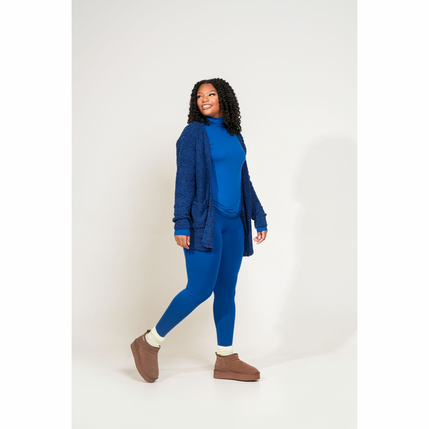Woman wearing a blue outfit with a cardigan on a white background. Cozy Pop Cardigan designed for soft, effortless living. Made from premium popcorn knit, this layer brings warmth, texture, and everyday comfort into one cozy essential.