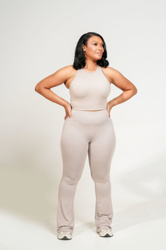 Woman wearing a beige athletic outfit on a white background. Brushed_DTY_Microfiber_blend_90_polyester_10_spandex_these_high-waist_flare_yoga_pants_feel_buttery_smooth_with_breathable_stretch_that_supports_gentle_movement_e