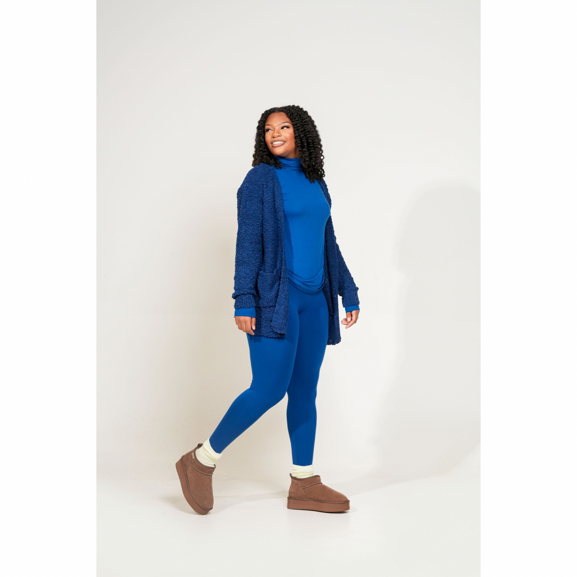 Woman wearing a blue outfit with a cardigan on a white background. Cozy Pop Cardigan designed for soft, effortless living. Made from premium popcorn knit, this layer brings warmth, texture, and everyday comfort into one cozy essential.